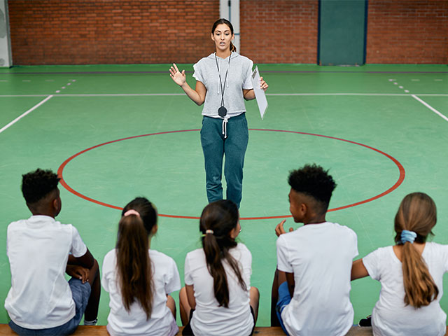 Female physical education teacher with class