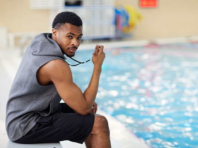 Swimming coach holding stop watch